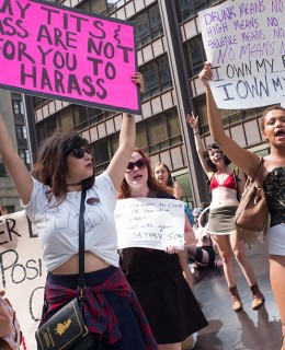 Woman holds sign that reads "My tits and ass are not for you to harass"