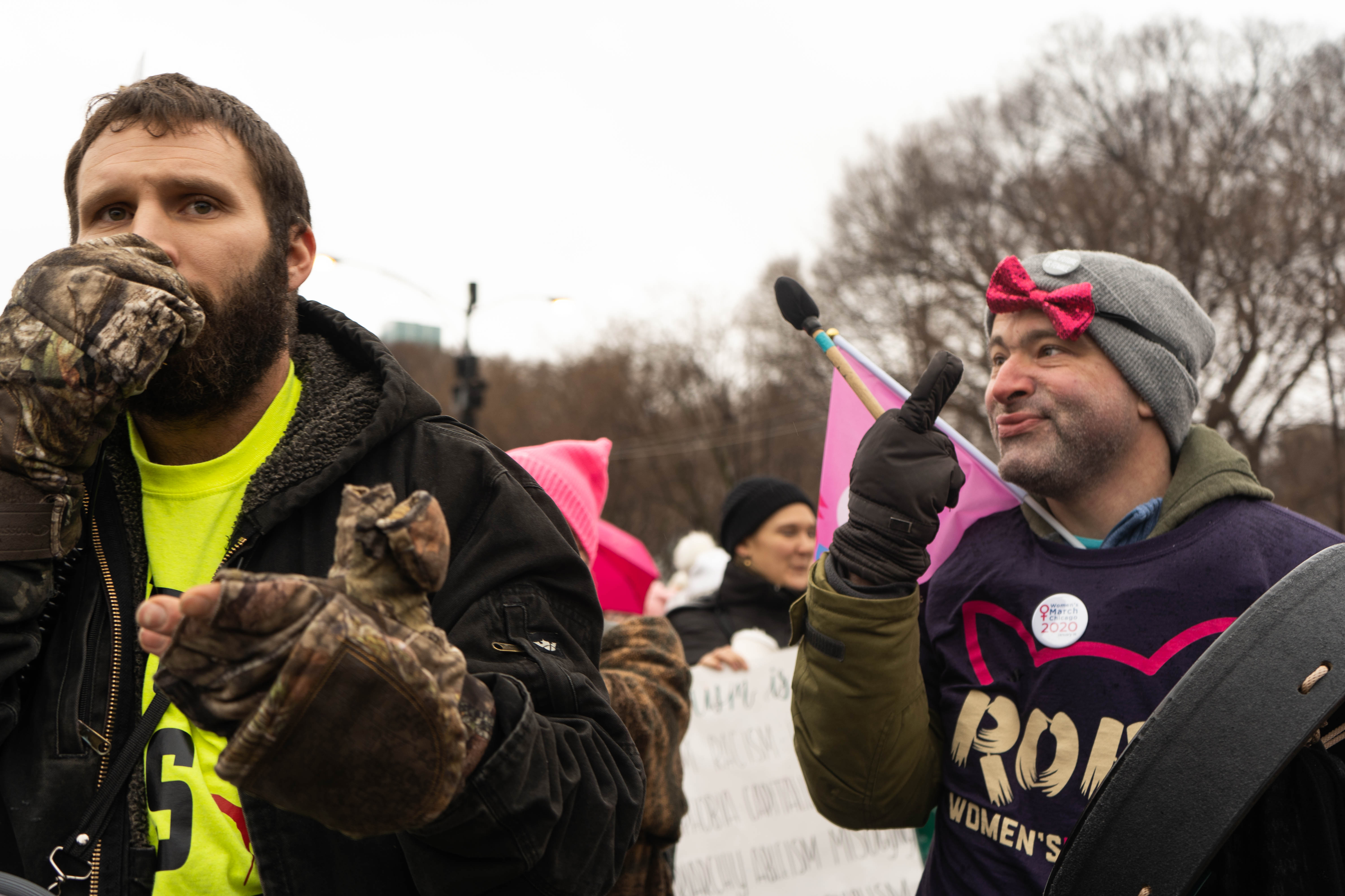 A women's march protester flips the protesting conservative the middle finger.