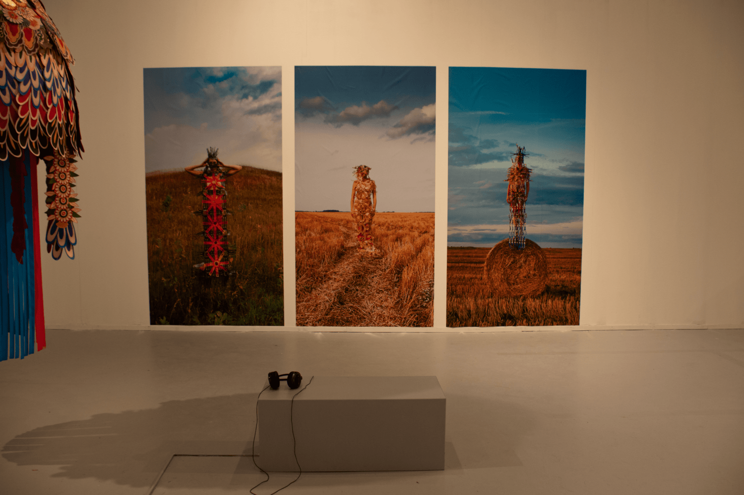3 images on a gallery wall featuring a figure.