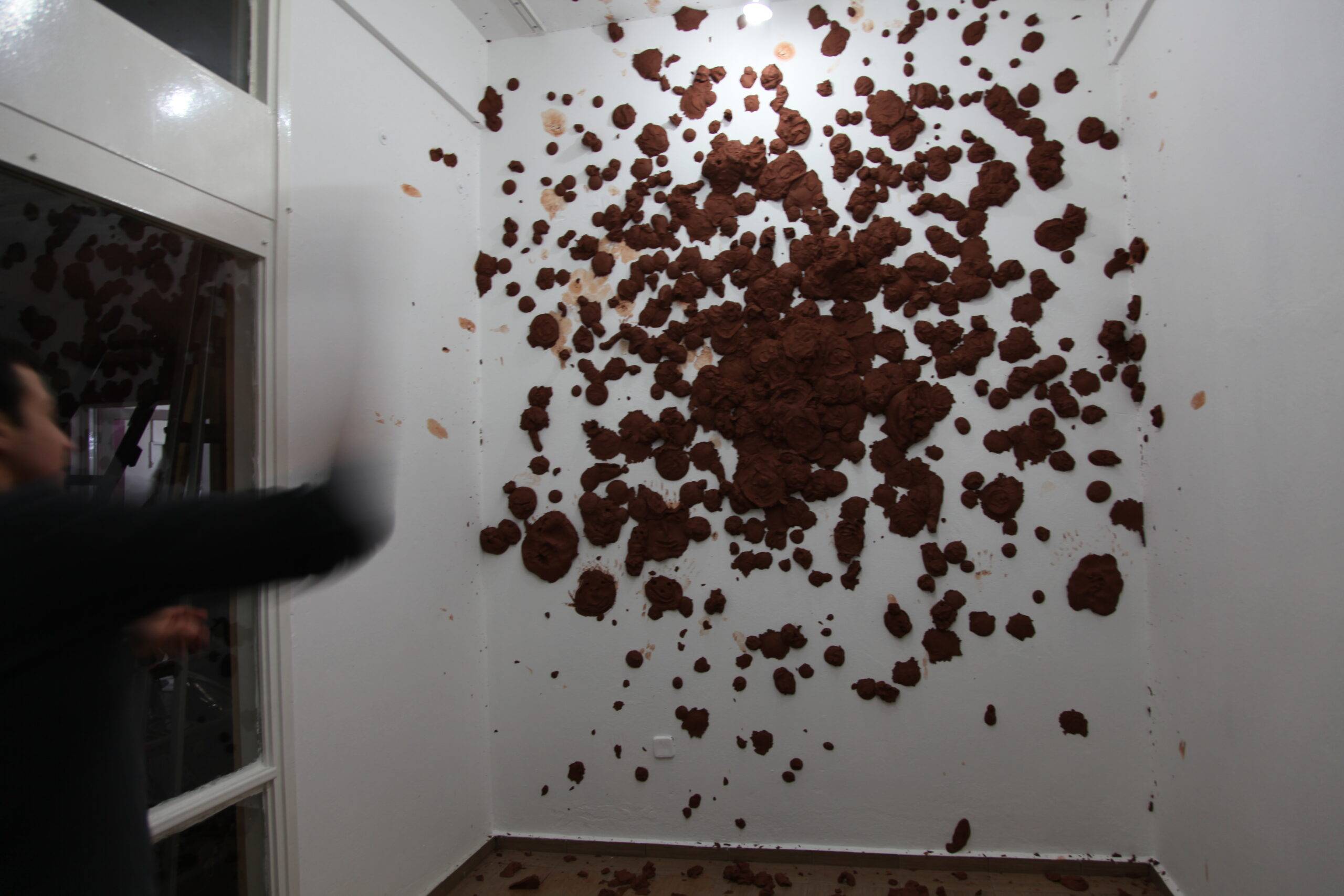 A person throws clay at the wall.