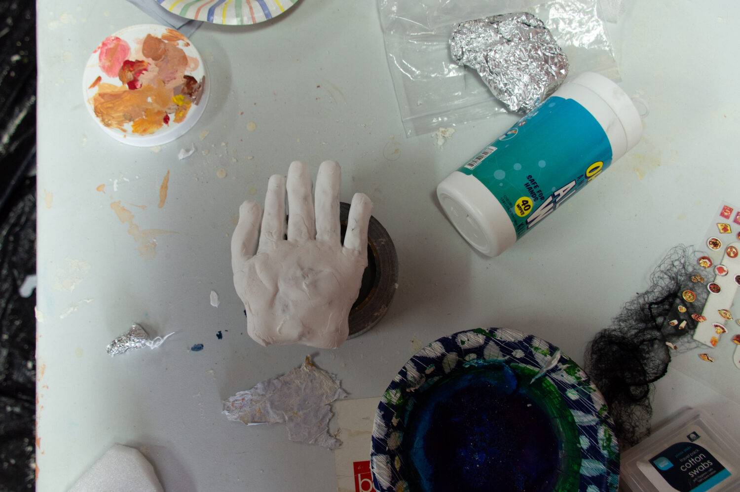  Hand made of clay surrounded by various materials on the main work table.