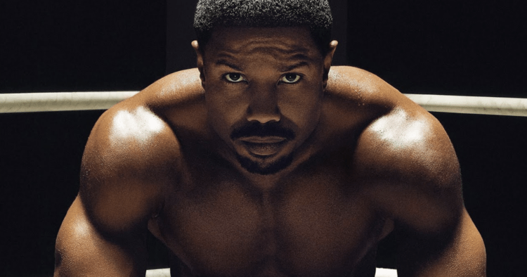 Close up of Michael B. Jordan's face as he sits shirtless in a boxing ring.