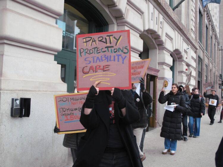 AIWU members and supporting protestors circle outside of the SAIC MacLean building at AICWU’s informational picket.