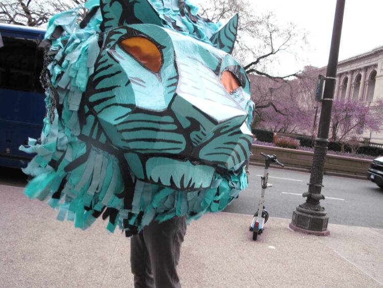 Protester holds AICWU’s lion mascot at AICWU’s informational picket.